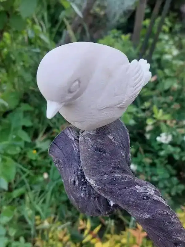Sculpture “Chanteur de pierre”, représentant un rouge gorge vu de profil dans la nature, réalisée par Danièle Archambault