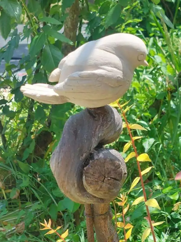 Sculpture “Chanteur de pierre”, représentant un oiseau vu de coté dans la nature, réalisée par Danièle Archambault